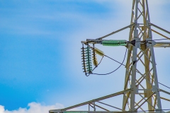 Line insulator on the electrical wires of a high-voltage tower.